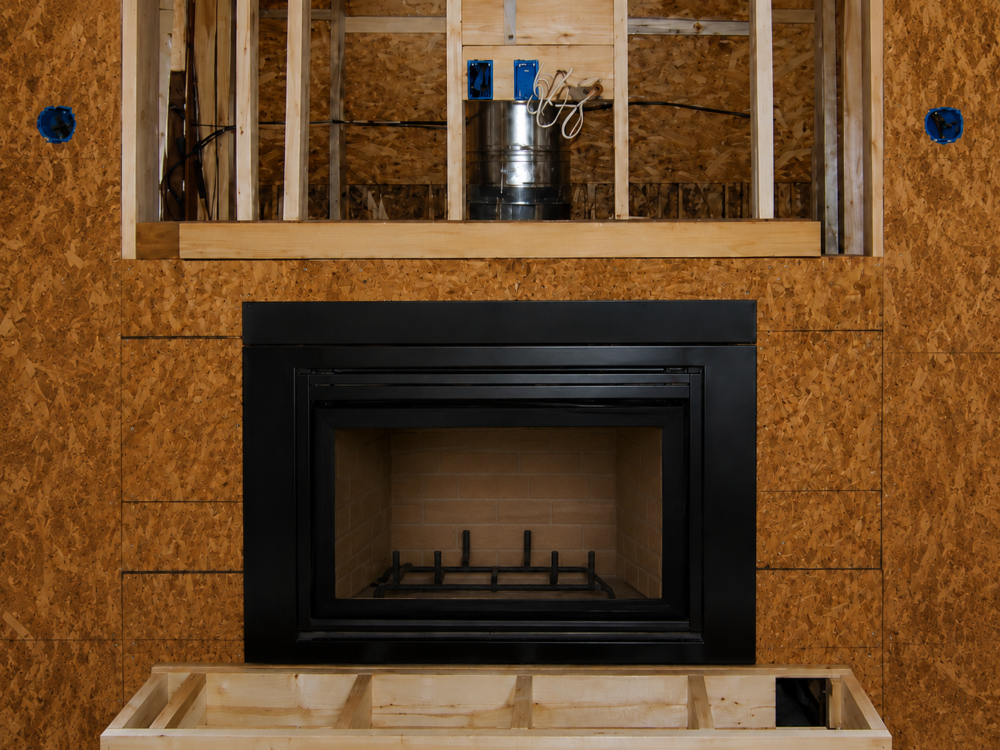 Modern zero clearance metal firebox fireplace with a lit fire.